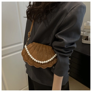 Détail du sac coquillage marron avec motif crocodile et anse décorative en perles