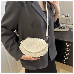 Détail du sac bandoulière blanc en forme de coquillage avec chaîne de perles et boucle
