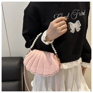 Sac à main rose en forme de coquillage avec anse en perles et texture pailletée