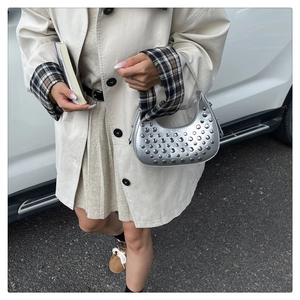 Dettaglio di una borsa hobo argento con borchie metalliche e finitura lucida