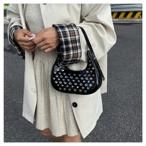 Vista street style di una borsa a mezzaluna nera con borchie argentate e manico corto chic