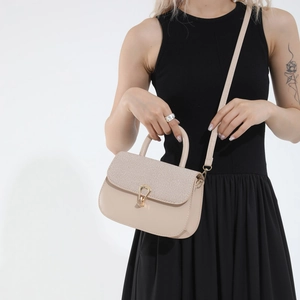 Minimalist beige contrast saddle bag with woven texture and gold buckle shown on a model