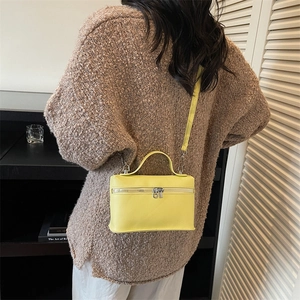 Minimalist bright yellow box-shaped crossbody handbag with top handle and metal zippers