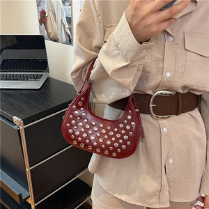 Borsa a mezzaluna rosso intenso con borchie argentate e pelle lucida per un look punk retrò