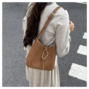 Vue détaillée du sac seau en cuir marron avec surpiqûres et boucle dorée