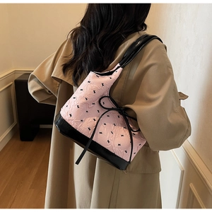Sac bandoulière en jacquard rose avec motif lapin et nœud noir porté par un mannequin