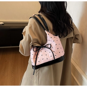 Détail du sac à bandoulière rose avec motifs papillons et anses en cuir verni noir