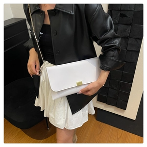Gros plan d'un sac enveloppe blanc minimaliste avec fermoir doré et fine bandoulière