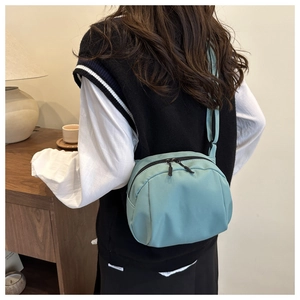 Rückansicht eines Models mit hellblauer Nylon-Umhängetasche in stilvoller Muschelform