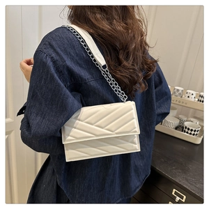 Vue détaillée du sac bandoulière blanc matelassé en similicuir avec chaîne argentée sur modèle