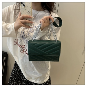 Vue détaillée du sac en cuir matelassé vert foncé avec coutures en V et bandoulière chaîne