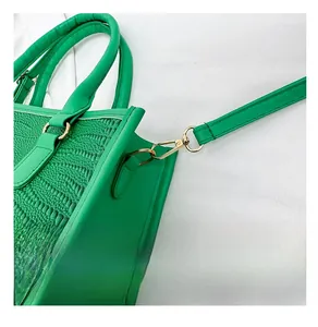 Dettaglio della borsa tote verde con stampa coccodrillo e finiture in metallo dorato