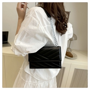 Détail du sac à bandoulière noir matelassé montrant la texture du cuir et la chaîne