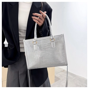 Dettaglio borsa tote argento goffrata coccodrillo con finiture in metallo dorato