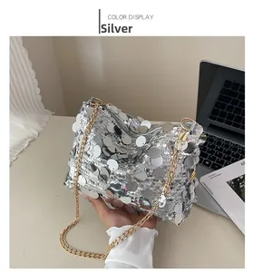 Detailed close-up of a silver sequin shoulder bag with elegant gold chain strap detail