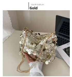 Close-up of gold sequin crossbody bag with chain strap and shiny metallic finish