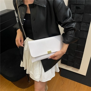 Sac bandoulière minimaliste en cuir blanc avec chaîne dorée et boucle sur le mannequin