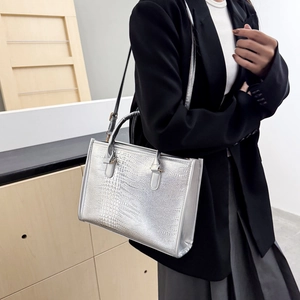 Borsa tote argento con stampa coccodrillo e dettagli dorati indossata da una modella