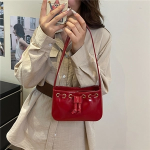 Chic red patent leather square handbag with drawstring detail and glossy finish