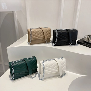 Sacs bandoulière matelassés avec chaînes en quatre couleurs sur un support d'exposition