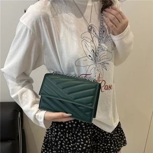 Sac bandoulière matelassé vert foncé avec chaîne argentée et couture moderne en V