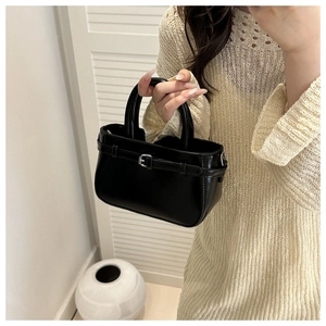 Détail de sac à main noir brillant en similicuir avec boucle fine et anneaux métal