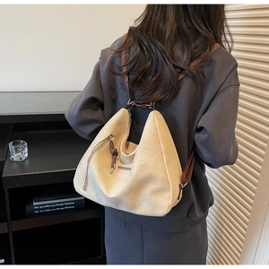 Detail of fashion canvas tote bag featuring side zipper pocket and brown shoulder strap