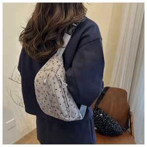 Vista posterior de bolso de pana gris con corazones y conejos llevado por una modelo