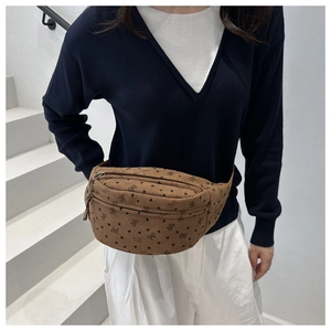 Sac bandoulière en velours côtelé marron avec motifs nœuds, porté par un mannequin chic