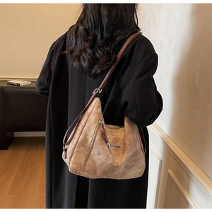 Close-up of vintage brown large capacity tote bag with decorative side zipper detail