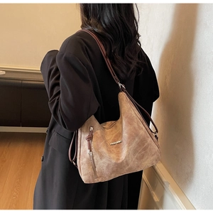 Brown vintage faux leather backpack shown from the back on a model in a black suit