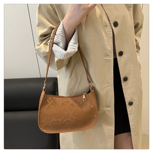 Close-up of brown snake-pattern texture on a crescent hobo bag with smooth metal zipper