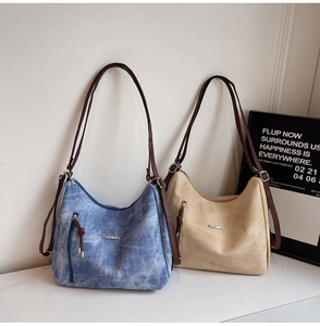 Detail of minimalist hobo bags in blue denim and beige finishes with brown straps