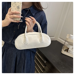 Minimalist white baguette bowling bag with dual handles and top zipper closure