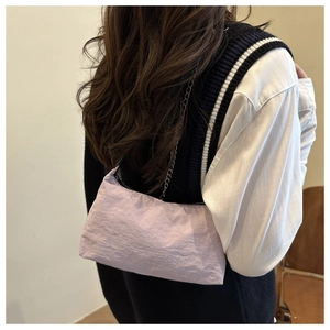 Detail of light purple nylon shoulder bag featuring a silver chain strap and wrinkled texture