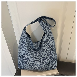 Detail view of blue leopard print canvas tote bag with thick shoulder straps and large capacity