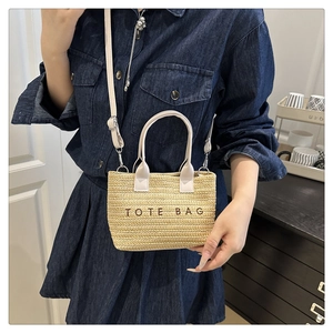 Détail du sac cabas en paille tressée avec bandoulière crème et motif TOTE BAG