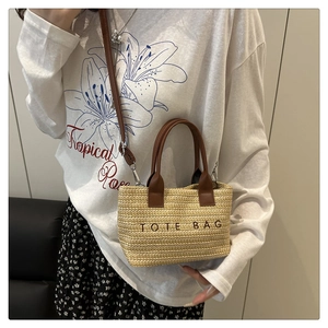 Détail du sac cabas en paille tissée avec poignées en cuir et broderie TOTE BAG
