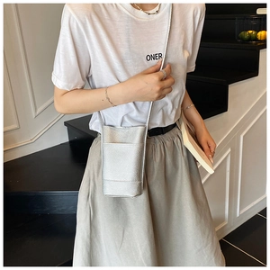 Detail of silver lychee texture synthetic leather bucket bag with slim shoulder strap