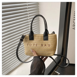 Détail du sac cabas en paille tressée avec poignées en cuir noir et broderie TOTE BAG