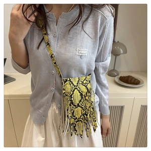 Mini yellow snakeskin crossbody bag with fringe detail styled with casual knitwear