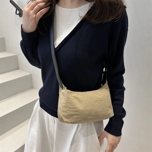 Minimalist beige nylon crossbody bag with slim black strap for daily casual commuting