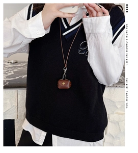 Mini leather pouch necklace with gold buckle and long strap shown on model neck