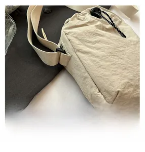 Détail du sac à cordon en nylon beige avec texture gaufrée et accents de cordes tressées