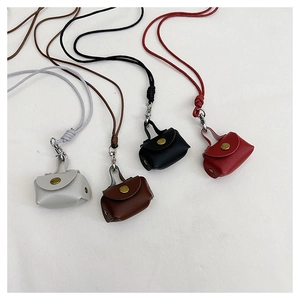 Detailed display of four leather mini pendant bags in grey, brown, black and burgundy