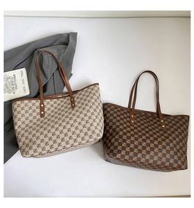 Flat lay of vintage beige and coffee tote bags with letter patterns on gray blazer