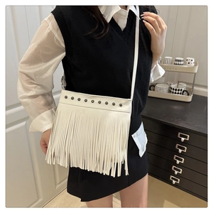 Détail du sac bandoulière bohème blanc avec clous argentés et longues franges déco