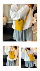 Détail d'un sac bandoulière en nylon jaune avec cordon et étiquette de mode