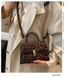 Close-up of leopard print baguette bag with gold hardware and stylish metal lock detail