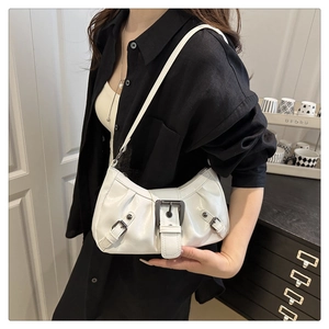 Detail of white pleated PU leather underarm bag with vintage metal buckles and shoulder strap